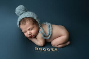 a newborn baby boy with bonnet snuggling houma Louisiana newborn photographer