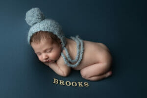 A 17 day old baby boy with blue bonnet and name at Lafayette Louisiana photography studio