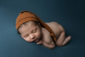 A sleepy baby boy with rust color sleepy hat at Baton Rouge LA photography studio. 