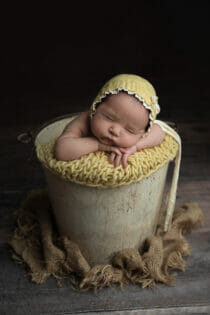 newborn baby girl bucket yellow bonnet cute expression