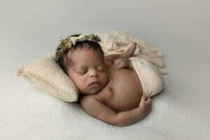 newborn baby girl swaddled womb pose with floral halo in New Orleans