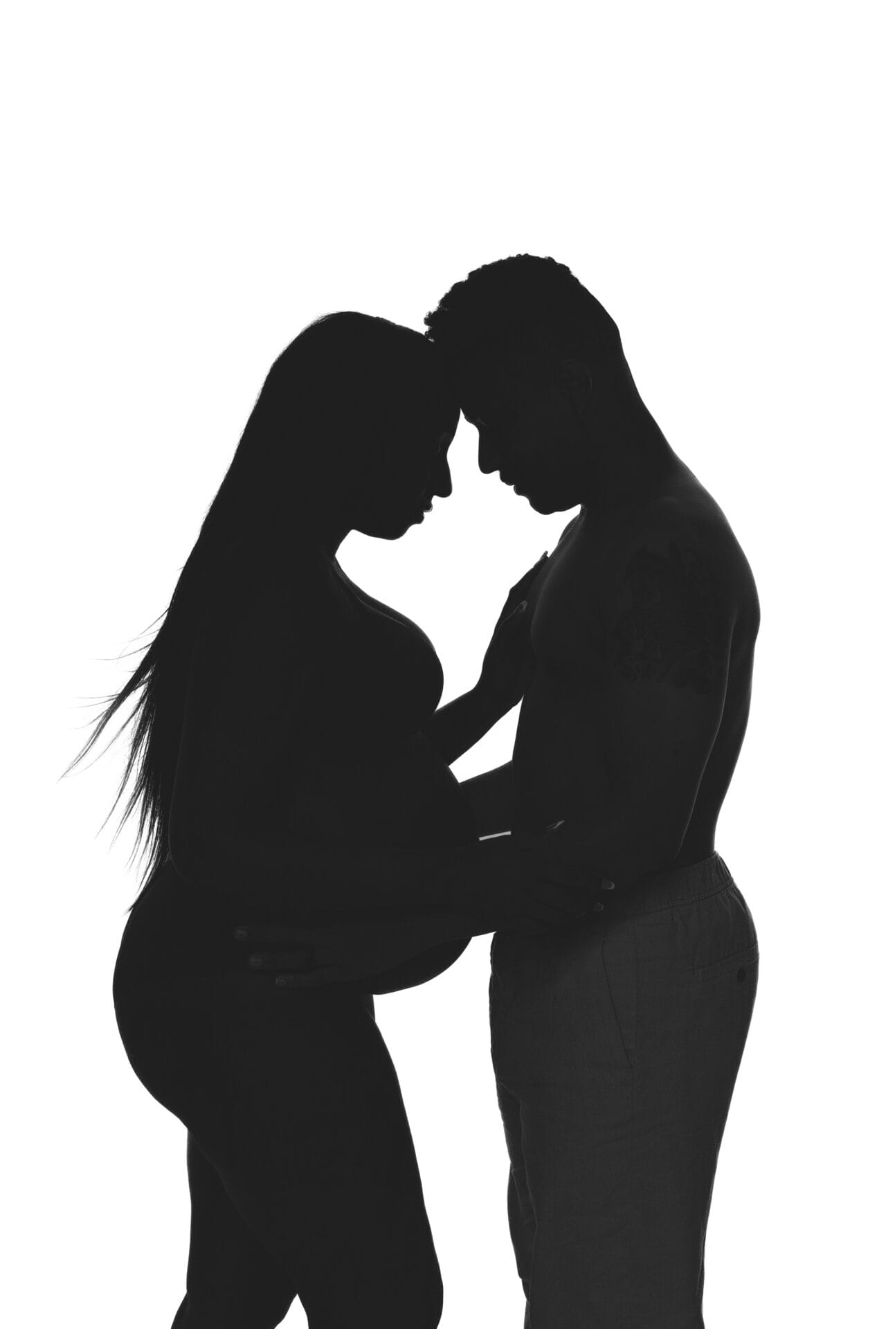 A couple, embracing affectionately New Orleans photographer capturing the essence of their pregnancy journey and the anticipation of welcoming their newborn baby.