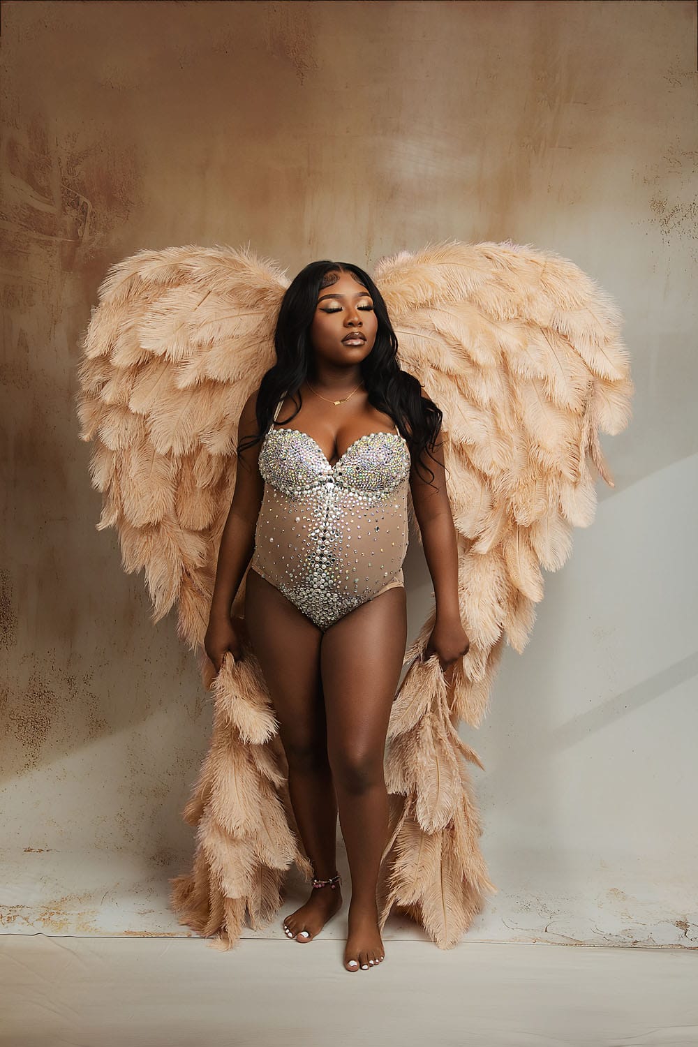 A pregnant mom in the studio wearing a bodysuit and angel wings with Lafayette prenatal yoga studio. 