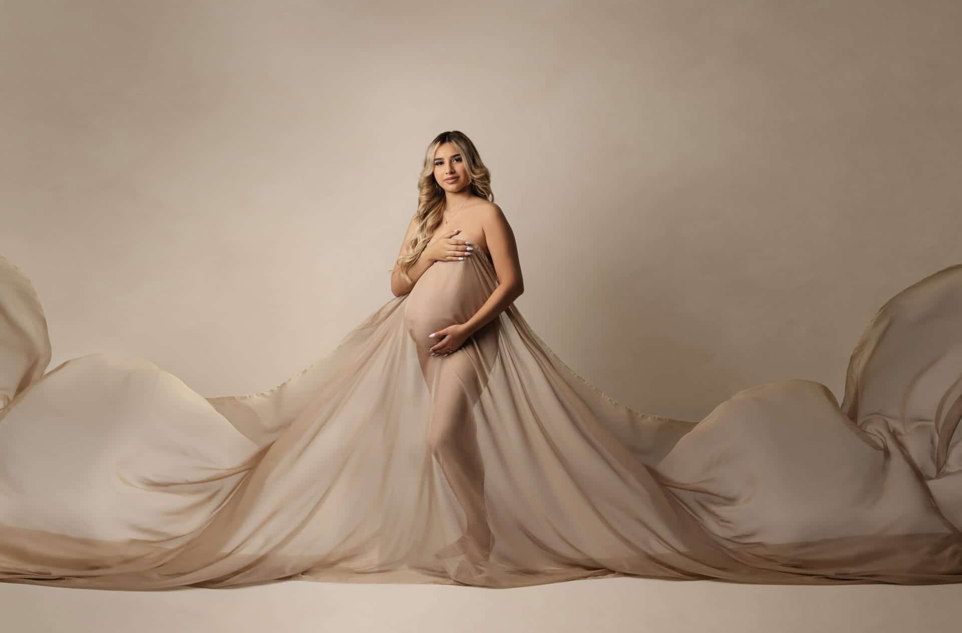 Flowing neutral maternity gown in studio