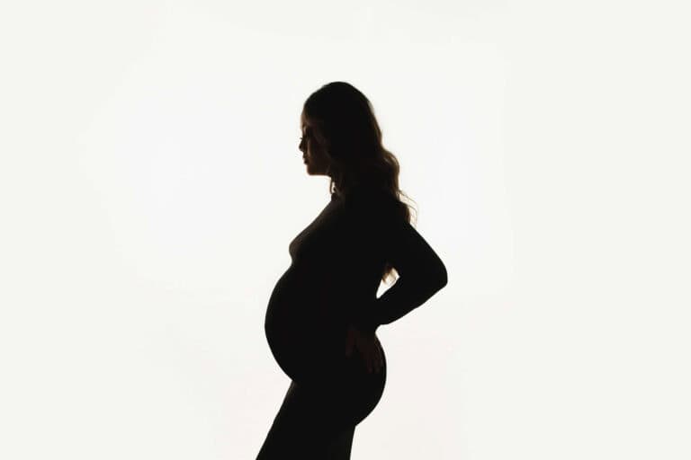 Maternity silhouette portrait highlighting baby bump in a New Orleans studio setting